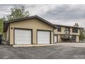 Charming exterior view featuring a two car garage and well-maintained lawn at 30839 Manitoba Dr, Evergreen, CO 80439
