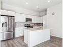 A modern kitchen is complete with stainless steel appliances, white cabinets, and an island at 487 Interlocken Blvd # 410, Broomfield, CO 80021