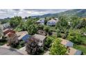 A serene aerial view of a Gathering-friendly neighborhood nestled amongst trees and picturesque hills at 573 Entrada Dr, Golden, CO 80401