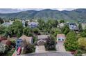 A high angle view of a residential neighborhood surrounded by green trees and mountains at 573 Entrada Dr, Golden, CO 80401