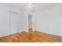 Bright bedroom features hardwood floors, a ceiling fan, and closet for ample storage at 11976 E Arizona Dr, Aurora, CO 80012