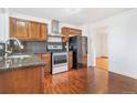 Traditional kitchen with wood cabinets, stainless steel appliances and hardwood floors at 11976 E Arizona Dr, Aurora, CO 80012