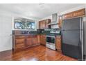 Traditional kitchen with wood cabinets, stainless steel appliances, dark counters and hardwood floors at 11976 E Arizona Dr, Aurora, CO 80012