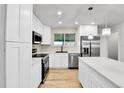 Modern kitchen with stainless steel appliances, white cabinetry and a beautiful backsplash at 12801 Randolph Pl, Denver, CO 80239