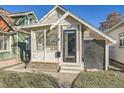 Quaint white cottage with a screened porch and well-maintained lawn at 4418 Utica St, Denver, CO 80212