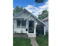 Charming white cottage with porch, landscaping, and black fence at 4418 Utica St, Denver, CO 80212