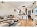 Open living space with L-shaped sofa, kitchen island, and hardwood floors at 4418 Utica St, Denver, CO 80212