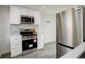 Modern kitchen features stainless steel appliances, white cabinetry, and a sleek microwave at 4835 Grove St, Denver, CO 80221