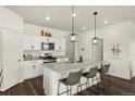 Bright kitchen offers white cabinets, pendant lighting, a granite-topped island with seating, and stainless appliances at 2326 Monte Vista St, Fort Lupton, CO 80621