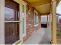 Inviting covered front porch featuring a stylish front door, stone accents, and ample natural light at 25812 E Cedar Pl, Aurora, CO 80018
