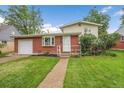Charming brick home with a well-maintained lawn and landscaping at 1330 Quari St, Aurora, CO 80011