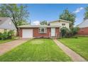 Charming brick home with a well-maintained lawn and landscaping at 1330 Quari St, Aurora, CO 80011