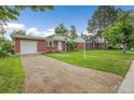 A charming brick home with a well-maintained lawn and gravel driveway at 1330 Quari St, Aurora, CO 80011