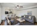 Open living area with a kitchen featuring a breakfast bar, seating, and modern gray furnishings at 4899 S Dudley St # 15G, Littleton, CO 80123