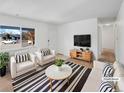 Bright living room with neutral walls, large window, and stylish black and white striped rug at 1584 S Salem Cir, Aurora, CO 80012