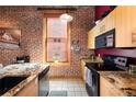 Charming kitchen with exposed brick, updated appliances, and a view, blending rustic charm with modern amenities at 1143 Auraria Pkwy # 203, Denver, CO 80204