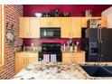 Modern kitchen with stainless steel appliances, granite countertops, and a stylish red accent wall, creating a chic space at 1143 Auraria Pkwy # 203, Denver, CO 80204