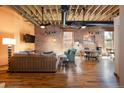 Inviting living room showcasing exposed brick walls, wooden beams, and hardwood floors with modern furnishings at 1143 Auraria Pkwy # 203, Denver, CO 80204