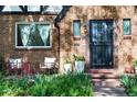 Charming brick home featuring a secure front door and flower-filled planters for added curb appeal at 1661 Oneida St, Denver, CO 80220