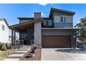 Charming two-story home featuring a covered front porch and a two-car garage at 10796 Truckee Cir, Commerce City, CO 80022