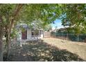 Backyard featuring a small lawn, chain link fence and mature trees at 1115 W Quincy Ave, Englewood, CO 80110