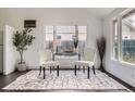 Bright seating area features hardwood floors, large windows, and comfortable chairs at 1115 W Quincy Ave, Englewood, CO 80110