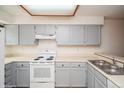 This kitchen features gray cabinets, white appliances, and bright countertops at 11147 W 17Th Ave # 105, Lakewood, CO 80215