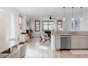 Bright, open-concept living room with wood floors and many large windows at 2034 Newton St, Denver, CO 80211