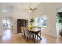 Bright dining room featuring vaulted ceilings, light hardwood floors, and a modern dining set at 15099 E Wagontrail Pl, Aurora, CO 80015