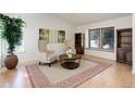 Bright living room featuring vaulted ceilings, light hardwood floors, and a neutral color palette with area rug at 15099 E Wagontrail Pl, Aurora, CO 80015