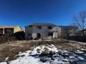 Two-story home with a large backyard, patio, basketball hoop, and partially snow-covered ground at 11383 Oakland Dr, Commerce City, CO 80640