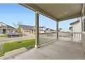 Relaxing covered front porch view showcasing neighborhood homes and green lawns at 1420 E Witherspoon Dr, Elizabeth, CO 80107