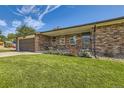 Brick house with a 2-car garage and rose bushes at 13627 W Alaska Dr, Lakewood, CO 80228