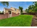 Large, grassy backyard with a brick retaining wall and a wooden fence at 11532 Newland St, Westminster, CO 80020