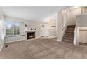Inviting living room with cozy fireplace, window seat, and staircase access at 11532 Newland St, Westminster, CO 80020
