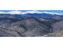 Expansive mountain range covered in trees and light vegetation, under a clear blue sky at 2433 Dogie Spur, Golden, CO 80403
