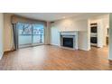 Living room with fireplace, hardwood floors, and sliding door to balcony at 444 S Kittredge St # 205, Aurora, CO 80017