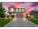 Charming two-story home with landscaped front yard, long driveway, and attached two-car garage at sunset at 7218 Animas Ave, Frederick, CO 80530