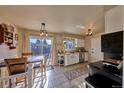 Eat-in kitchen with sliding glass door, ample sunlight, white cabinets and tile floors at 1922 S Ivory Way, Aurora, CO 80013