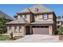 Beautiful home exterior with stone accents, tan siding, and a tiled roof at 6878 Northstar Ct, Castle Rock, CO 80108