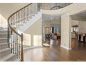 Inviting foyer with hardwood floors, staircase, and open view to the living spaces at 6878 Northstar Ct, Castle Rock, CO 80108