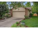 Charming home exterior features a two-car garage with stone accents and landscaped yard at 7582 S Newport Ct, Centennial, CO 80112