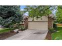 Charming home exterior features a two-car garage with stone accents and landscaped yard at 7582 S Newport Ct, Centennial, CO 80112