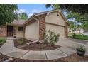 Charming home exterior features a two-car garage with stone accents and landscaped yard at 7582 S Newport Ct, Centennial, CO 80112
