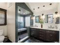 Modern bathroom with tiled shower, dual vanity, and contemporary fixtures at 2591 Albion St, Denver, CO 80207