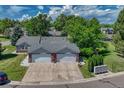 Aerial view of a well-maintained duplex with a spacious driveway, beautiful landscaping, and a lush green surrounding at 5173 S Emporia Way, Greenwood Village, CO 80111
