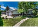 Exterior view of a duplex featuring well-manicured landscaping, lush greenery, and a charming walkway to the entrance at 5173 S Emporia Way, Greenwood Village, CO 80111