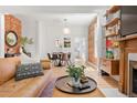 Bright living room showcasing hardwood floors, exposed brick, and open layout to the dining area at 480 S Grant St, Denver, CO 80209