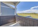 A view from the balcony overlooking a prairie, with cloudy skies overhead and modern architecture nearby at 2702 E 103Rd Ave, Thornton, CO 80229