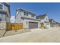 A two-car garage with a brown door and light gray siding set in a new community with blue sky above at 2702 E 103Rd Ave, Thornton, CO 80229